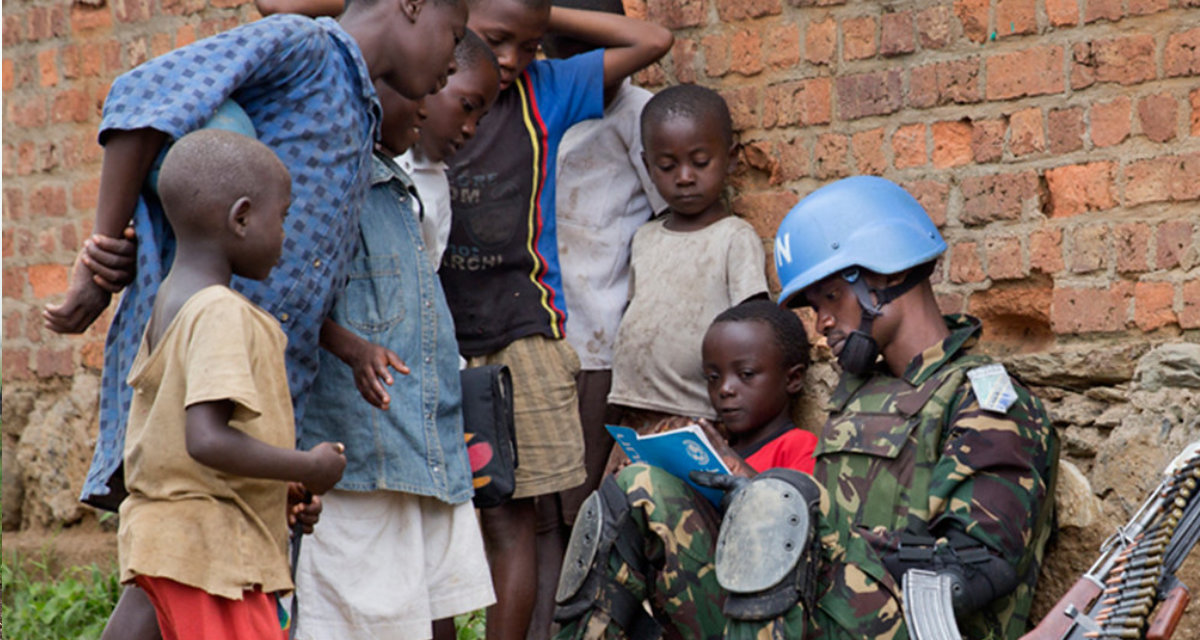 A peacekeeper of MONUSCO Force Intervention Brigade on foot patrol in the town of Pinga, North Kivu province, stops to interact with the local children. DR Congo. | Flickr | MONUSCO | CC BY-SA 2.0 A peacekeeper of MONUSCO Force Intervention Brigade on foot patrol in the town of Pinga, North Kivu province, stops to interact with the local children. DR Congo. | Flickr | MONUSCO | CC BY-SA 2.0
