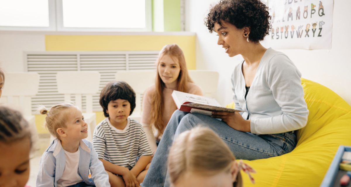 Am Boden sitzende Kinder bekommen eine Geschichte vorgelesen. Foto: Yan Krukau/Pexels | Canva | Servicestelle Friedensbildung